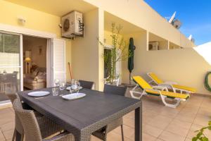 a dining room with a table and chairs on a patio at Casa Amiga in Praia do Carvoeiro