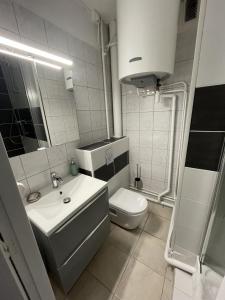 a white bathroom with a sink and a toilet at Tegmen, Joli appartement au calme in Caen