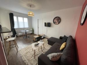 a living room with a couch and a table at Tegmen, Joli appartement au calme in Caen
