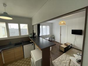 a kitchen with a counter and a table in a room at Tegmen, Joli appartement au calme in Caen +2 photos