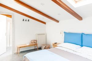 Schlafzimmer mit einem blauen Bett und einem Tisch in der Unterkunft Villa Angela B&B in Sant'Egidio del Monte Albino