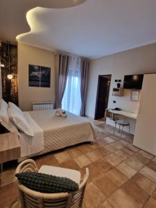 Hotel La Rocca في سان مارينو: غرفة نوم كبيرة بها سرير وطاولة وكراسي