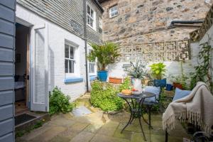 a small courtyard with a table and a building at Saffron Cottage, St Ives in St Ives