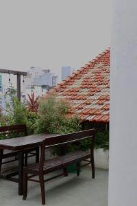 stół i ławka na balkonie z dachem w obiekcie Nhà bình Homestay w mieście Da Nang