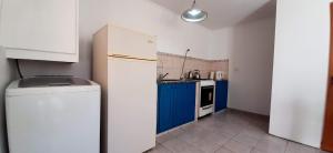 cocina con nevera blanca y armarios azules en Rufilandia Dúplex para 2 personas Zona El Calvario en Tandil