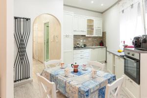 a kitchen with a table and chairs and a kitchen with white cabinets at Da Crys & Symo parcheggio privato in Sanremo