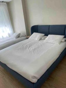 2 camas con sábanas blancas y almohadas en un dormitorio en Piso de lujo en centro de valladolid, en Valladolid