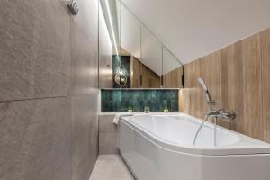 a bathroom with a white tub and a mirror at Apartament Czorsztyn 2 in Kluszkowce