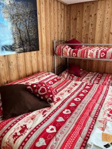 two beds in a room with red and white blankets at Residenze Vezza - La Corteccia- in Vezza dʼOglio