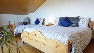 una camera con 2 letti con cuscini blu di La Pecora Nera Bed & Breakfast Belluno a Belluno