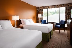 a hotel room with two beds and a window at Greenwood Inn & Suites in Corner Brook