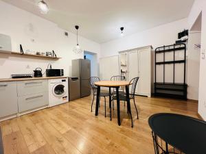 a kitchen with a table and chairs in a room at Melody Apartment in Krakow
