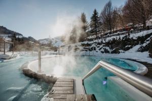 a hot spring with a slide in the snow at Familien- & Gartenhotel Theresia 4-Sterne Superior in Saalbach-Hinterglemm
