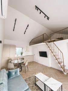 a living room with a staircase and a table at Genio apartamentai Kunigiskiuose in Palanga