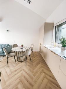 a kitchen and living room with a table and chairs at Genio apartamentai Kunigiskiuose in Palanga