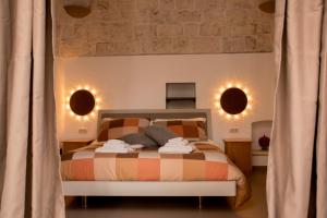 a bedroom with a bed with two lights on the wall at Pavì Trulli e Suites in Locorotondo