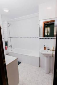 a bathroom with a sink and a tub and a toilet at 2 Bedroom Apartment Lloret de Mar Terrace & Pool in Lloret de Mar