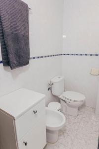 a white bathroom with a toilet and a sink at 2 Bedroom Apartment Lloret de Mar Terrace & Pool in Lloret de Mar
