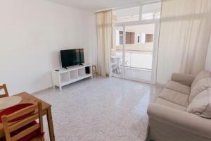 a living room with a couch and a tv at 2 Bedroom Apartment Lloret de Mar Terrace & Pool in Lloret de Mar