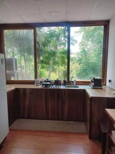 eine Küche mit einem Waschbecken und einem großen Fenster in der Unterkunft ROOM AYAMPE - La Casa de Eros in Ayampe