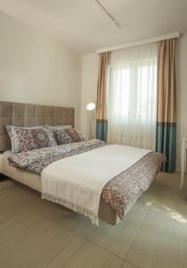 a bedroom with a large bed and a window at Apartmani Freedom place in Jagodina