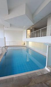 a large swimming pool with blue water in a building at SK's Crib - Fully Furnished Condo @ Primavera Apts in Cagayan de Oro