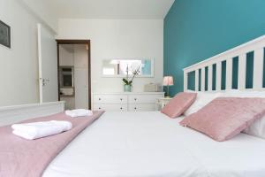 a bedroom with two beds with pink and white sheets at In the heart of the city in Heraklio