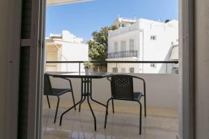 a table and chairs on a balcony with a window at In the heart of the city in Heraklio