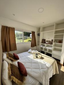 1 dormitorio con 1 cama blanca grande y ventana en El Mirador en Salta