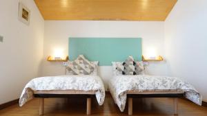 a bedroom with two beds and two lights on the wall at B&B La Pecora Nera in Belluno