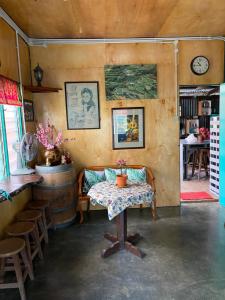 una habitación con una mesa y un reloj en la pared en New Famer Hut 1, en Brinchang