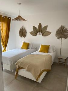 een slaapkamer met twee bedden en twee planten aan de muur bij Les Lodges de Saint Brice 2 in Arès