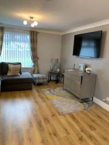 a living room with a couch and a flat screen tv at Dyce Flat - Near Airport in Dyce