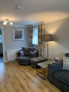 a living room with a couch and chairs and a table at Dyce Flat - Near Airport in Dyce