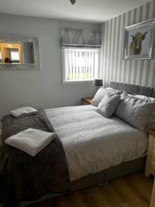 a bedroom with a bed and a mirror on the wall at Dyce Flat - Near Airport in Dyce