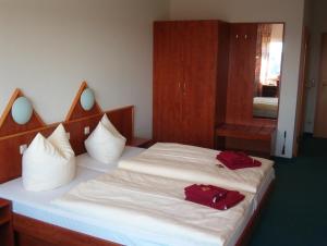 - une chambre avec un lit doté de 2 oreillers rouges dans l'établissement Hotel und Gasthaus Rammelburg-Blick, à Friesdorf
