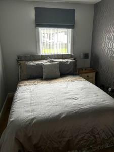 a bedroom with a large bed with a window at Dyce Flat - Near Airport in Dyce