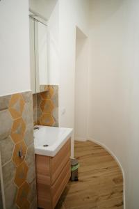 La salle de bains est pourvue d'un lavabo et d'un miroir. dans l'établissement Salerno City Apartments, à Salerne