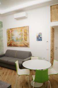 - un salon avec un canapé, une table et des chaises dans l'établissement Salerno City Apartments, à Salerne