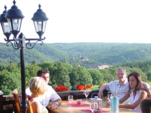 a group of people sitting at a table with a view at Hotel und Gasthaus Rammelburg-Blick in Friesdorf