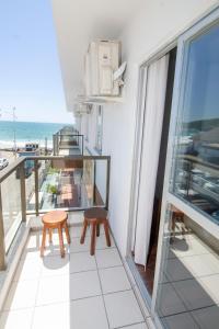 d'un balcon avec deux chaises et une vue sur l'océan. dans l'établissement Residencial Primavera, à Bombinhas