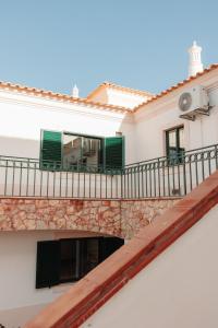 a balcony of a building with green shutters at Casa Velha Apartments - Adults friendly in Albufeira