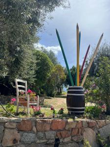 a flower garden with a chair and a plant at Agriturismo Su Barraccu in Loceri