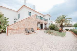 a house with two chairs in front of it at Casa Velha Apartments - Adults friendly in Albufeira
