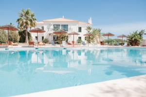 a large swimming pool in front of a house at Casa Velha Apartments - Adults friendly in Albufeira