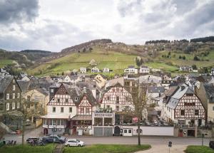 a town with houses and cars on a hill at Hotel Reiler Hof in Reil
