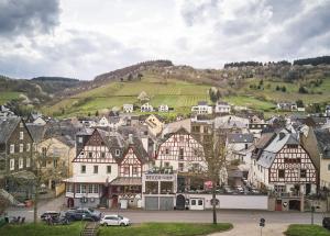 eine Stadt mit Häusern und Autos auf einem Hügel in der Unterkunft Hotel Reiler Hof in Reil