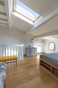 - une grande chambre avec un lit et une lucarne dans l'établissement Jolie maison de pêcheur - La Pointe Courte, à Sète