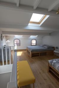 Cette chambre mansardée comprend deux lits et un banc jaune. dans l'établissement Jolie maison de pêcheur - La Pointe Courte, à Sète