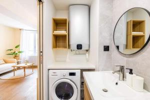 a bathroom with a washing machine and a sink at escapade aux portes de Paris in Suresnes